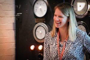 Landscape image of Dr Justine Reilly with clocks in the background