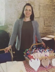 Clare Hales standing by a table, smiling